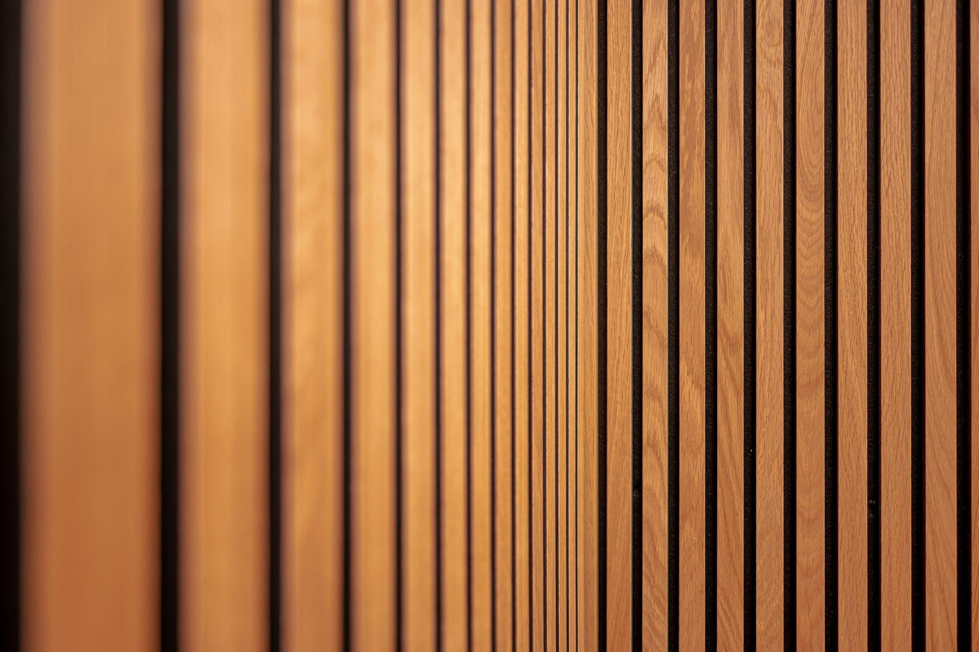 Close-up of a warm wood slat wall with even vertical spacing
