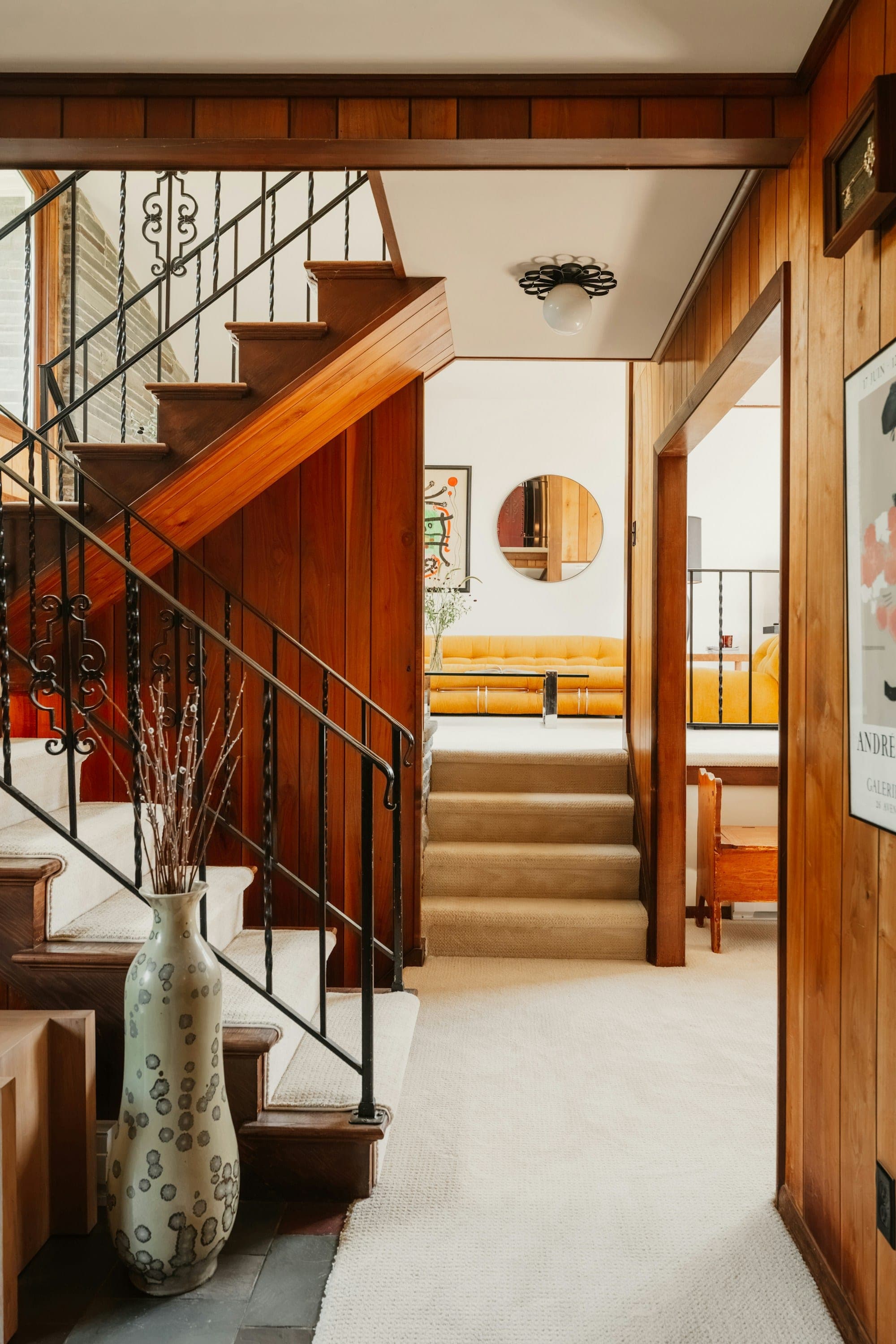Staircase in a warm wood-paneled hallway with a metal railing