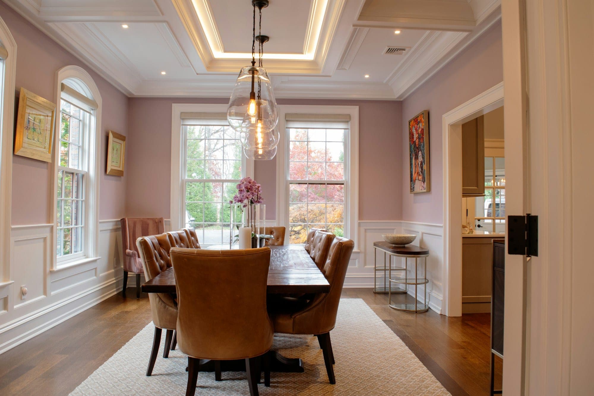 Dining room with wainscoting, window casings and a coffered ceiling with crown molding